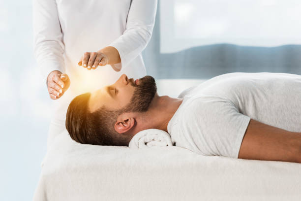 healer putting hands above head of young man